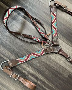 a pair of leashes laying on top of a wooden floor