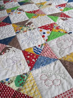 a close up of a quilt on a bed with polka dots and circles in the center