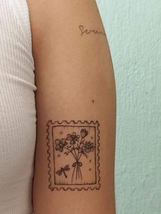 a woman's arm with a stamp and flowers on it