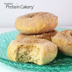 three sugary donuts stacked on top of each other in a green glass plate