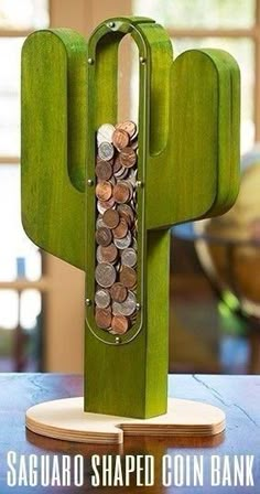 a cactus shaped coin bank sitting on top of a wooden table