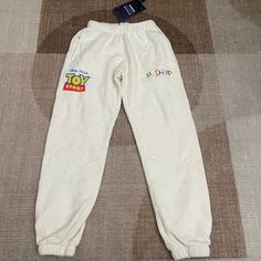 Nwt Madhappy X Pixar Toy Story Cream Sweatpants Sz: Small (S) *Sweatpants Has A Tiny Stain* Nmh02 Playful White Pants For Loungewear, Playful White Bottoms For Loungewear, Playful White Loungewear Bottoms, Playful White Bottoms With Pockets, Cream Sweatpants, Light Blue Sweatpants, Mad Happy, Brown Sweatpants, Happy Logo