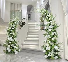 white flowers and greenery decorate the entrance to a house