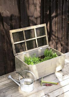 an old wooden box filled with plants sitting on top of a table