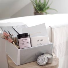 a white box with candles, soaps and other items sitting on a wooden table