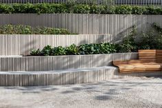 a wooden bench sitting next to a stone wall