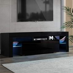 a flat screen tv sitting on top of a black entertainment center in a living room