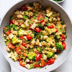 a bowl filled with broccoli, tomatoes and cauliflower