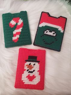 three crocheted christmas coasters on a white furnishing with snowman and candy cane