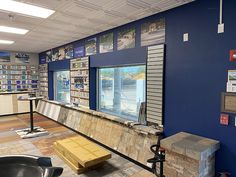 the inside of a store with several different items on display in front of windows and pictures on the wall