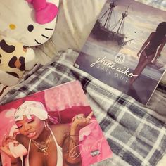 a hello kitty stuffed animal laying on top of a bed next to an album cover