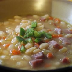 a bowl filled with soup and vegetables on top of a table