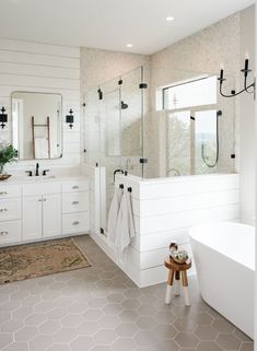 a white bathroom with two sinks and a bathtub