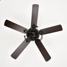 an overhead view of a ceiling fan with dark wood blades and four light brown blades