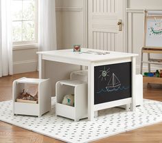 a child's play table with chalkboard in the center and storage bins underneath