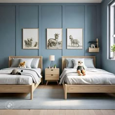 two beds in a room with blue walls and pictures on the wall above them, one has a teddy bear