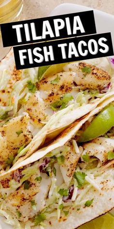 two fish tacos on a plate with limes