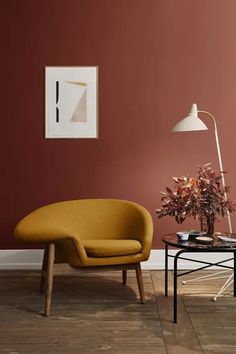 a living room with red walls and a yellow chair next to a small coffee table