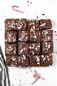 chocolate peppermint brownies with candy canes on the side and white background