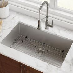 a stainless steel sink in a kitchen with marble counter tops