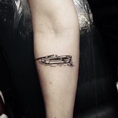 a person with a small tattoo on their arm that has a boat in the water