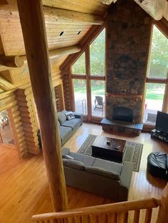 a living room filled with furniture and a fire place in the middle of a wooden floor