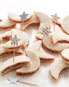 some food that is laying out on a table with toothpicks in the shape of stars and crescents