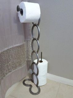 a toilet paper holder made out of two rolls of toilet paper and a metal chain