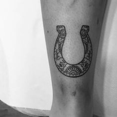 a black and white photo of a horseshoe tattoo