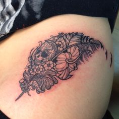 a woman's thigh with a skull and flowers tattoo design on the side of her thighs