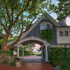 an arch in front of a gray house