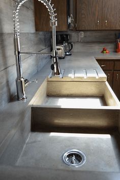 a kitchen sink sitting under a faucet next to a counter top with a drain