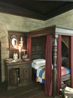 a bedroom with a four poster bed and wooden flooring, along with red curtains