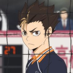 an anime character behind a fence looking at the camera with serious expressions on his face