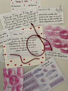 several handwritten notes are laid out on top of each other, with red string attached to them