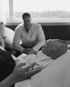 two people sitting on a couch and one is holding a baby