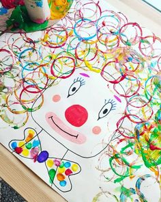 a child's drawing of a clown with lots of colored streamers on it