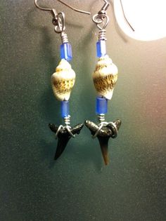 the earrings are decorated with shells and blue beads