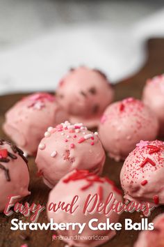 strawberry cake balls with sprinkles and chocolate frosting on a wooden board