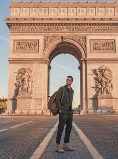 a man standing in front of the arc de triumph