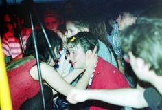 a group of young people sitting next to each other in a room full of people