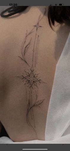 the back of a woman's shoulder with a flower tattoo on it