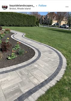 a stone path in the middle of a grassy area with flowers and plants growing on it