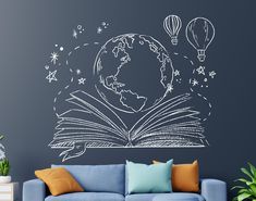 a living room with a blue couch and an open book on the wall that is drawn in chalk