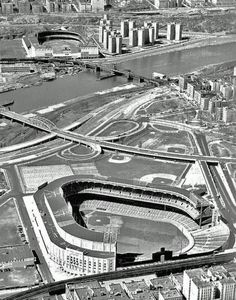 an aerial view of a baseball stadium in the middle of a city with lots of tall buildings