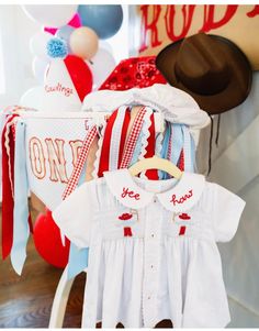 baby clothes and balloons are on display at a birthday party