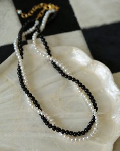 Experience the timeless contrast between black onyx and white pearls with this simple yet striking design. Natural pearls add a soft beauty, while black agate adds a unique charm. This necklace can be DIY by yourself. The two beads are scattered and have a sense of hierarchy. They are twisted together and have a sense of design.But you can't take it apart and wear it alone~ Necklaces Pearl, Natural Pearl Necklace, Soft Beauty, Gemstone Beaded Necklace, Pearl Necklaces, Natural Pearl, Black Agate, Design Simple, Unique Charms