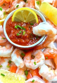 a plate with shrimp, lemon wedges and ketchup