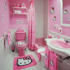 a bathroom decorated in pink and white with hello kitty rugs