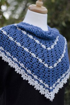 a blue and white crocheted shawl on top of a mannequin